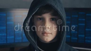 一个天才男孩黑客天才的肖像在引擎盖的背景显示器与程序代码。 年轻的黑客